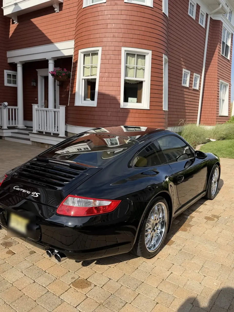 Black Porsche 911 Carrera 4S with chrome wheels after a monthly detail