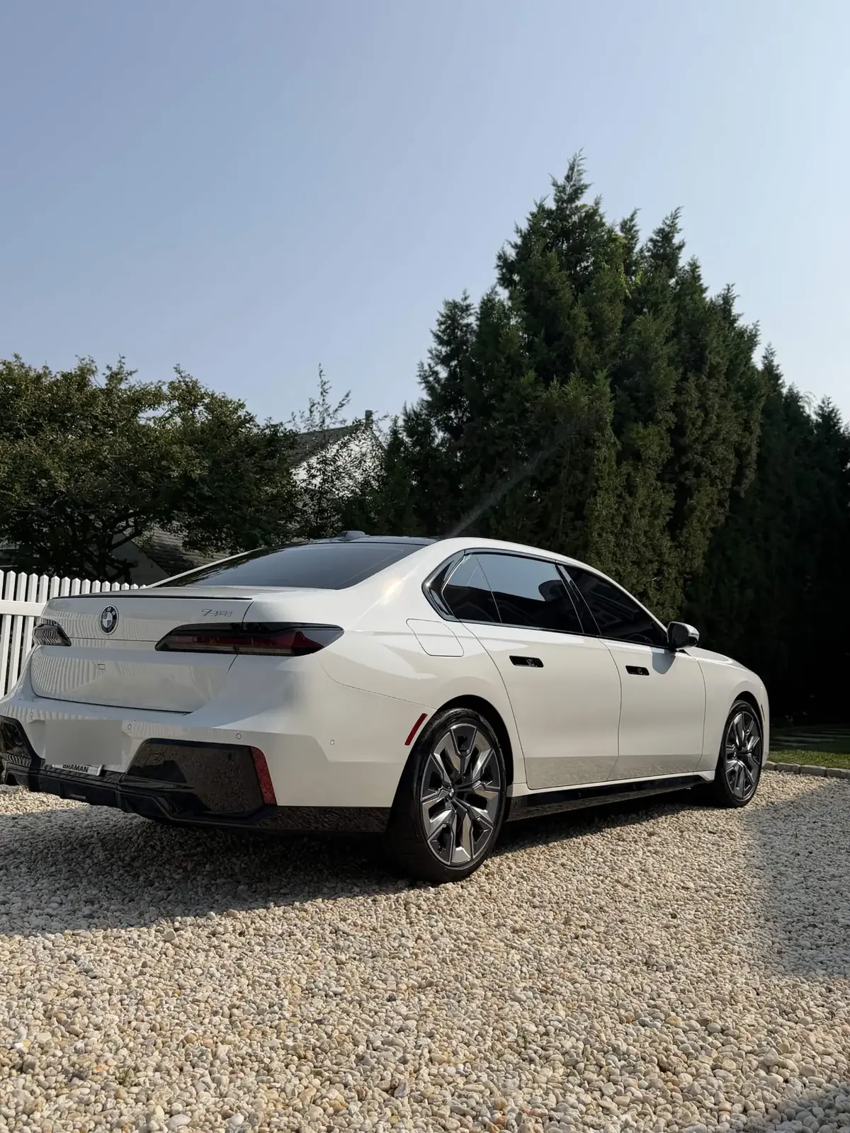 White BMW 740i on a gravel drive