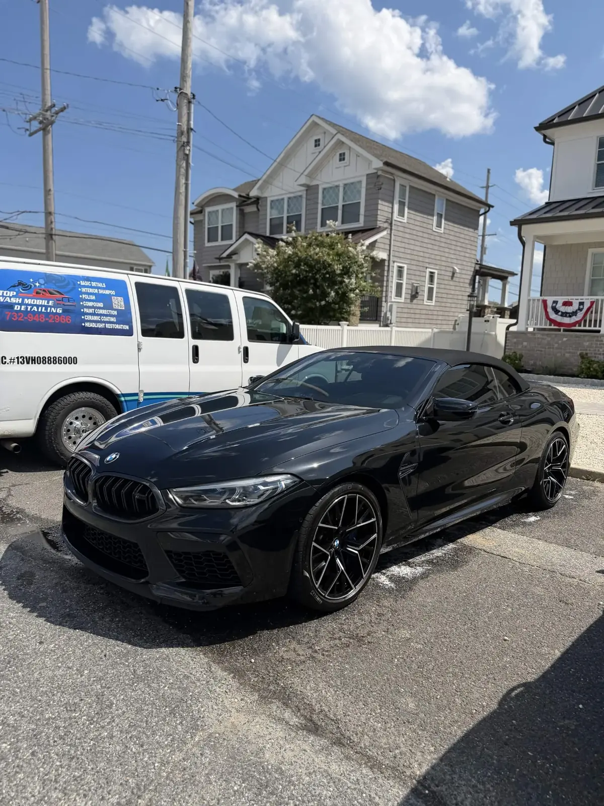 Black BMW M8 Competition convertible next to the Top Wash van
