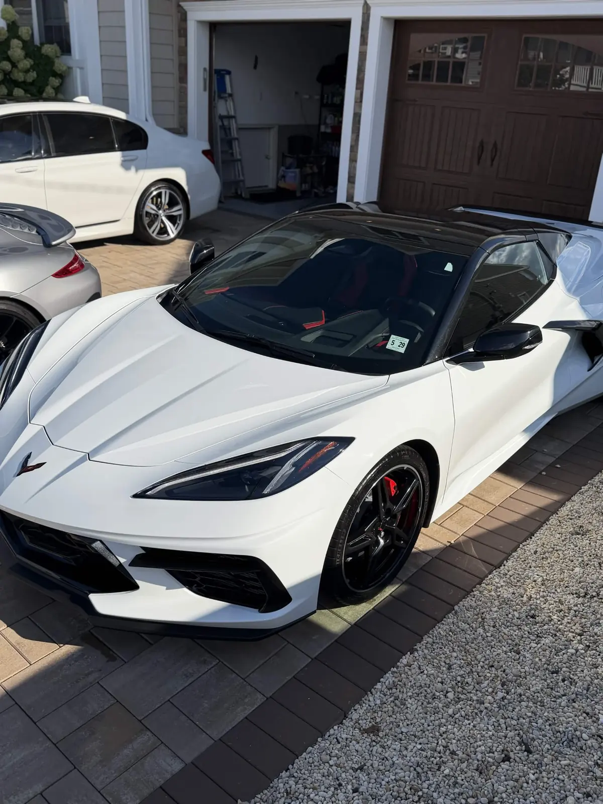 White C8 Corvette with black roof in a driveway