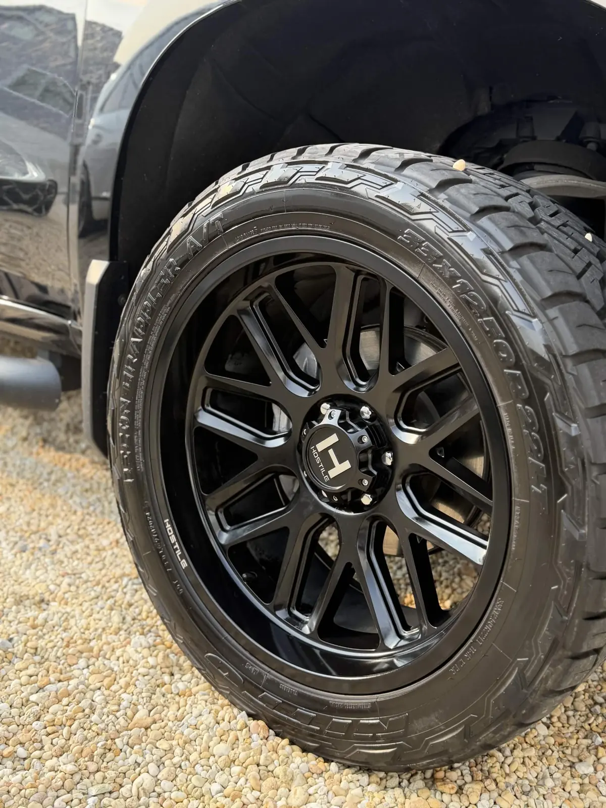 Gloss black truck wheel and dressed all-terrain tire